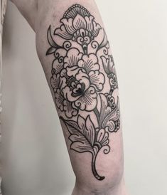 a black and white flower tattoo on the right arm, with an ornate design around it