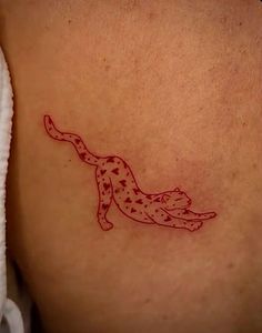 a cat tattoo on the back of a woman's left shoulder and leg,