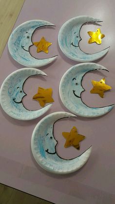 three paper plates with gold stars and crescent moon shapes on them, one is painted blue and the other is yellow