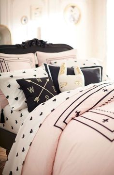 a bed with black and white comforters and pillows