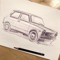 a drawing of a car is shown on a piece of paper next to a pen