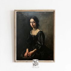 a portrait of a woman in a black dress hangs on the wall next to a white wall