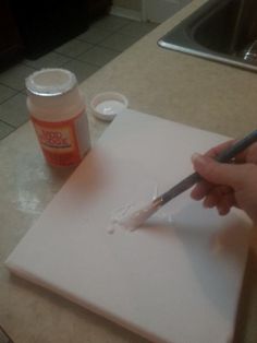 someone is using a sharpie to draw something on a piece of paper with a paintbrush