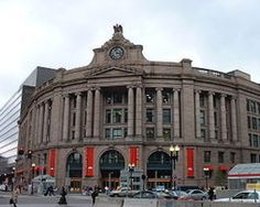 a large building with a clock on it's face in the middle of a street