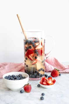 blueberries, strawberries and other fruit in a pitcher