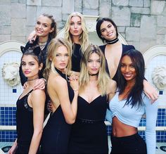 a group of women standing next to each other in front of a fountain