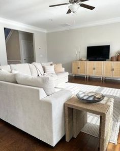 a living room filled with furniture and a flat screen tv on top of a wooden floor