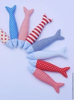 five different colored fish made out of fabric on a white surface with red, white and blue stripes