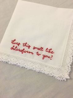 a white handkerchief with red embroidered words on it