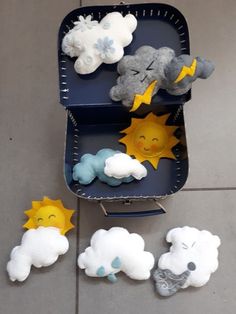 there are stuffed animals in a suitcase on the floor next to other items that look like clouds, sun and stars