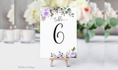 a table number with flowers and candles in the background