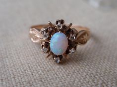 Antique Opal Diamond Ring 10k.  This elegant lady is from around the early 1900s.  She has a gorgeous center oval opal that is surrounded by 6 dainty rose cut diamonds.  She is a size 7 and weighs 2.3g.  The center stone measures approx. 6mm x 5mm and her overall setting is 11.4mm north to south.  She appears to be in wonderful shape for her age although, as expected with her age, there is some wear to the opal, please see pictures. She is unmarked and has tested as 10k.  She would make a stunning alternate engagement ring as well as a wonderful gift for an October lady. All items are in previously loved, used condition so please review all photos closely and let me know if you have any questions prior to purchasing. I'm not a jeweler or gemologist & I pass on all information available to Victorian Oval Opal Ring For Anniversary, Victorian Opal Oval Cabochon Ring For Wedding, Victorian Oval Cabochon Opal Wedding Ring, Victorian Oval Opal Ring For Wedding, Victorian Style Oval Opal Ring For Wedding, Victorian Opal Ring For Wedding, Vintage Oval Opal Wedding Ring, Victorian Diamond Ring, Opal Diamond Ring