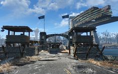 an image of a bridge that is in the middle of some dirt and grass with flags flying above it