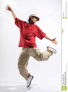 a young man in red shirt and khaki pants doing a jump with his arms outstretched