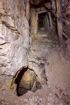 an underground tunnel in the side of a mountain with rocks and dirt on both sides