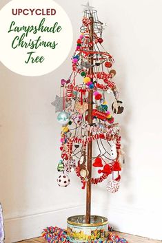 a christmas tree with ornaments hanging from it's sides and the words upcycled lampshade christmas tree below