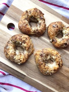 four doughnuts sitting on top of a wooden cutting board