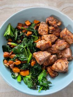 a blue bowl filled with meat and veggies