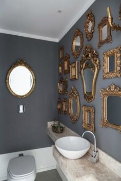 a bathroom with several mirrors on the wall and a sink in front of an oval mirror