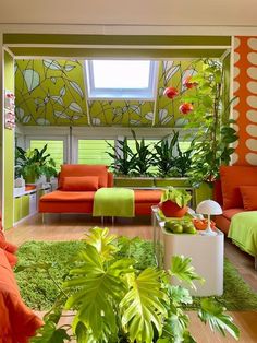 a living room filled with lots of green furniture and plants on the floor next to each other