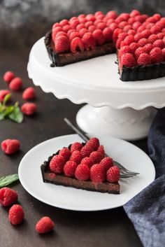 a slice of chocolate cake with raspberries on top