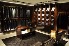 a well - lit walk in closet with clothes on shelves