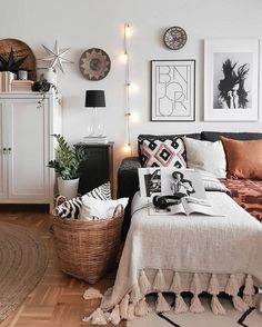 a bedroom with white walls and pictures on the wall next to a bed, wicker basket