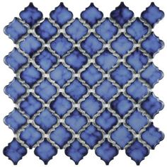 a blue and white mosaic tile with diamond design on it's side, in the shape of a square