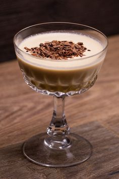 a dessert in a glass on top of a wooden table