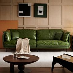 a living room with green leather furniture and pictures on the wall