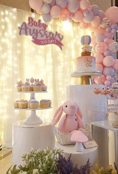 a baby shower party with balloons, cupcakes and stuffed animals