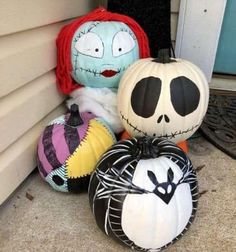 three pumpkins and two jack - o - lanterns sitting on the ground