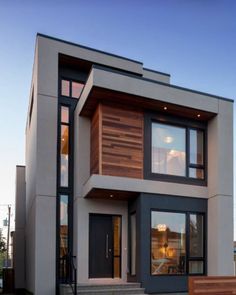 a modern house with wood and glass on the front door, stairs leading up to it's second floor