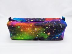 This Rainbow Colored Galaxy Zippered Pencil Pouch is quite roomy, you can store your entire 24 colored pencils and still have room for more. Or it could hold your makeup brushes and cotton pads, or perhaps your dice for your next game session? It would make a great party favors as well - message me for bulk orders! [Features] - Roughly 8" long x 2.25" tall x 2.5" wide - Lightly structured with interfacing [Care Instruction] - Spot clean if possible - Hand wash gently and air dry when needed - Use lukewarm water with gentle soap - Avoid wringing or twisting - Can be ironed on cotton setting to form the shape again after washing * This listing is only for the zippered pouch. Props used in the photos are not included. ** I can customize this item! Fabric print, pouch size, and more - don't he Multicolor Pouch Pen Holder, Kawaii Multicolor Pouch Pencil Case, Multicolor Pouch Bag With Pen Holders, Multicolor Pencil-shaped Pencil Case For Travel, Multicolor Pencil-shaped Pencil Case For Daily Use, Kindle Paperwhite, Cotton Set, Pencil Pouch, Pen Case