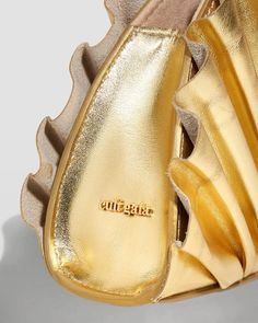 a pair of gold shoes that are on top of each other, with the soles showing