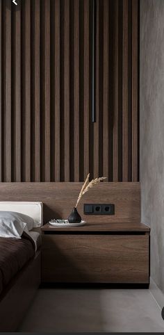 a modern bedroom with wooden slats on the headboard and side table in front of it