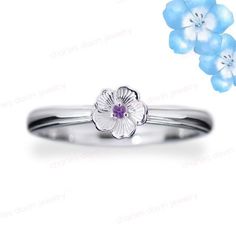 a white gold ring with blue flowers on it