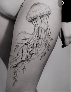 a black and white photo of a jellyfish tattoo on the right side of the thigh