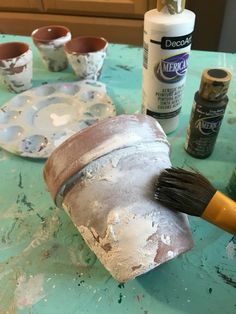 the paint is being used to make an art project with clay and other items on the table