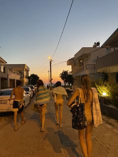 three women walking down the street at sunset