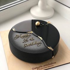 there is a black cake with gold lettering on it