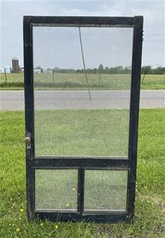 an old black door sitting in the grass