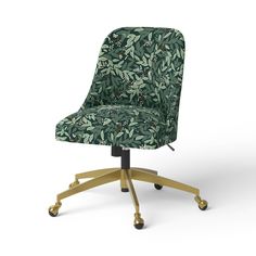 an office chair with green leaves on the back and gold casteors, against a white background