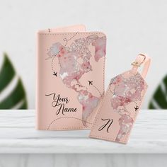 two pink passport cases with the map of the world printed on one side and an air plane painted on the other