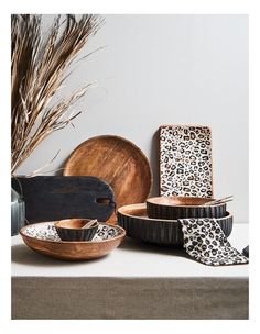 a table topped with bowls and plates covered in animal print