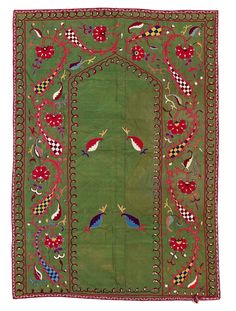 an old green rug with birds and flowers on the border, in front of a white background