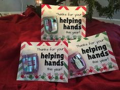 three handprinted greeting cards on top of a bed with christmas lights in the background