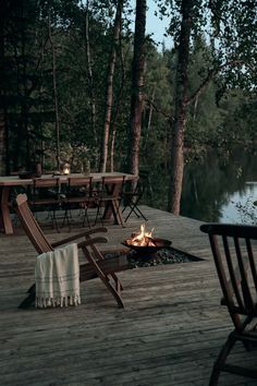 an article in the magazine shows a fire pit and chairs on a wooden deck next to a lake