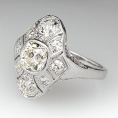 This beautiful circa 1930s ring features an 18K white gold gallery with a a pierced design and bordered with milgrain edging. The platinum shank has a slightly rounded profile. The ring is centered with one (1) old mine cut diamond weighing 1.37 carats and set into a bezel. The center stone is bordered with two (2), bead set, old mine cut diamonds and six (6), bead set, old European cut diamonds. The ring measures 19.6mm at the top, rises 6.7mm above the finger, tapering to 2.0mm wide and 1.2mm thick at the base of the shank. This ring is currently a size 8. The ring shows some gentle overall wear and the shank has been replaced. One of the accent diamonds has an edge chip. Antique Cushion, Cushion Diamond, Amethyst Jewelry, European Cut Diamonds, February Birth Stone, High Quality Jewelry, Estate Jewelry, Diamond Shapes, Platinum