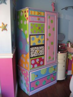 a brightly colored dresser in a child's bedroom with polka dots on the drawers